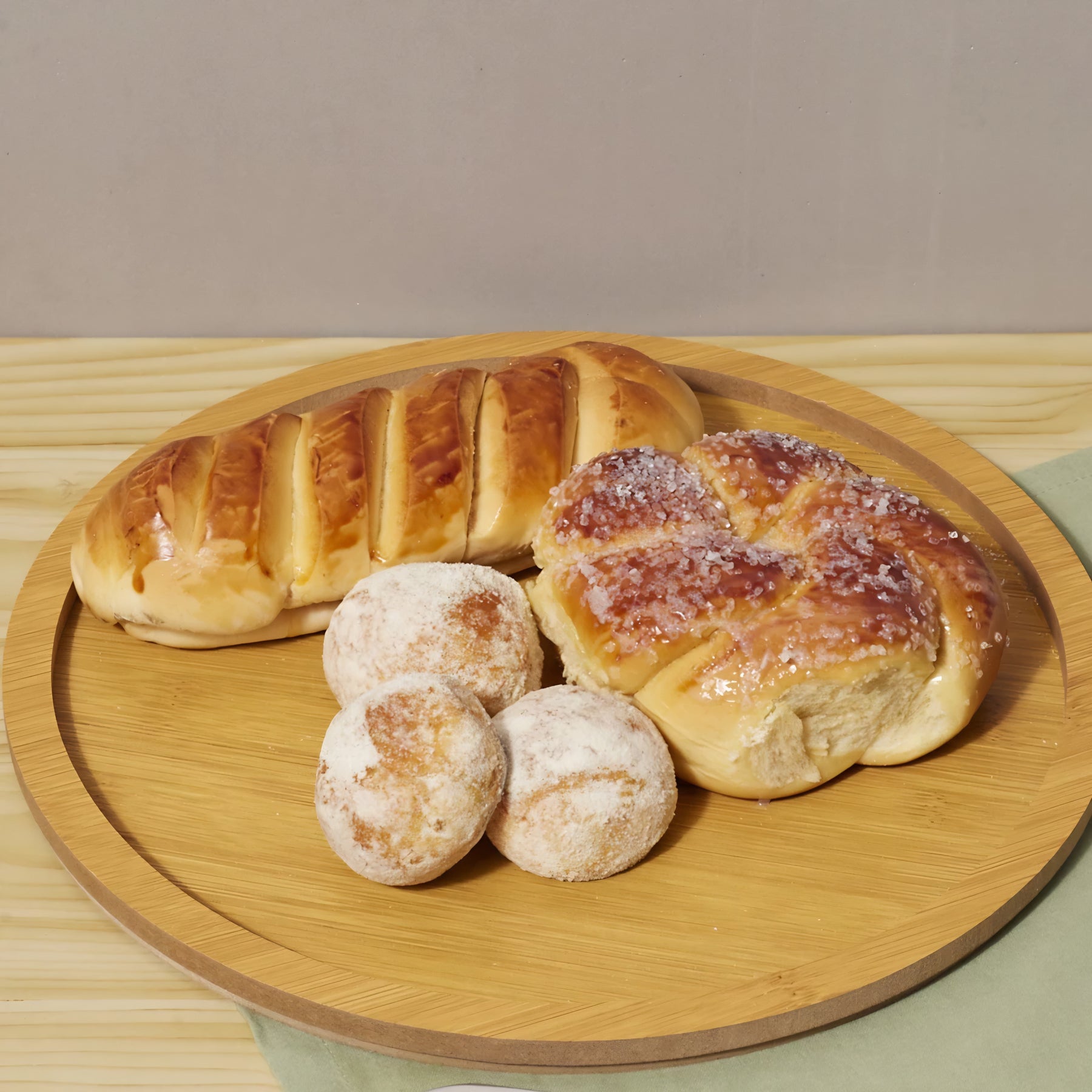 Prato redondo de bambu servindo uma refeição com um filé de frango grelhado e pães.