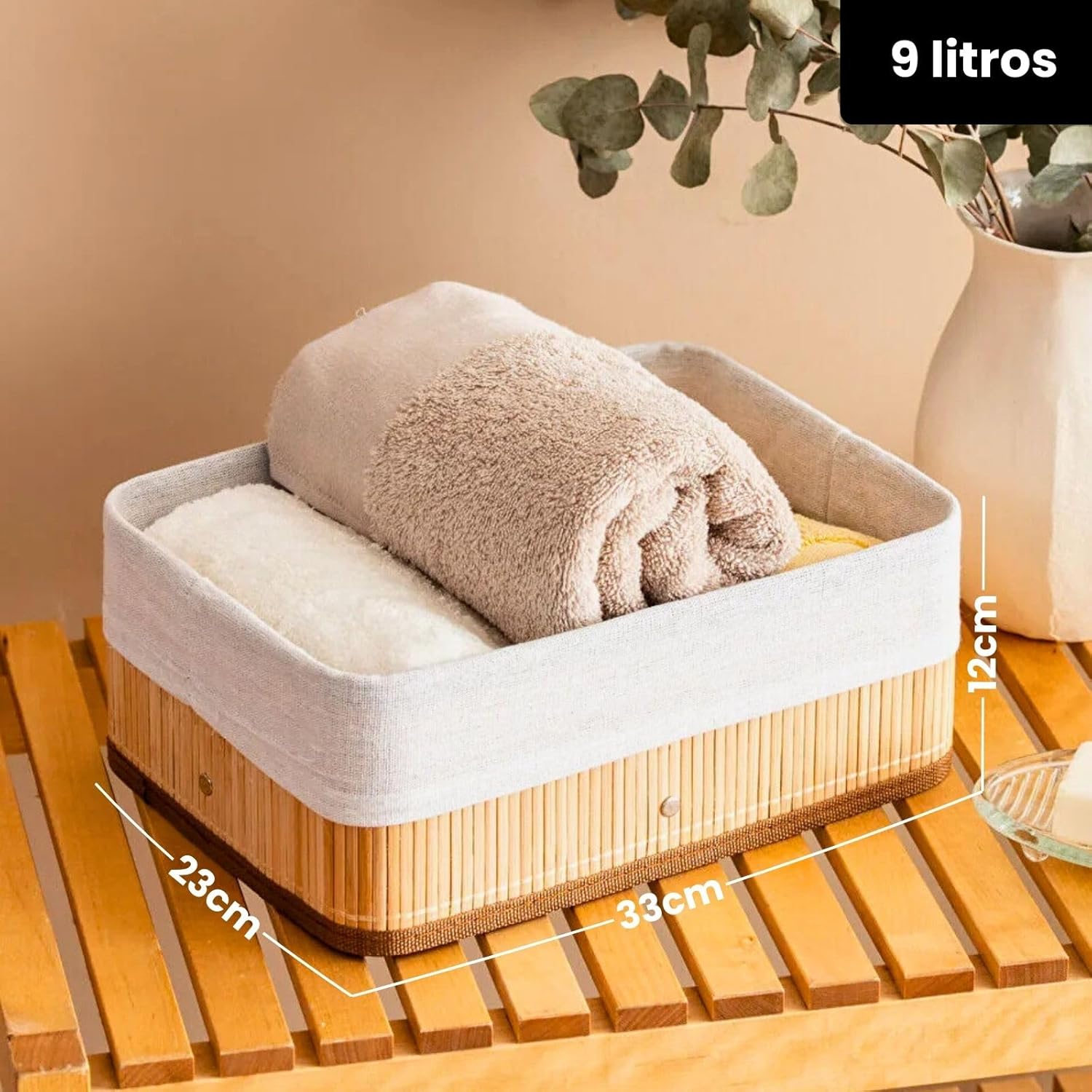 Cesto quadrado de bambu com capacidade de 9 litros, contendo uma toalha de banho marrom enrolada.