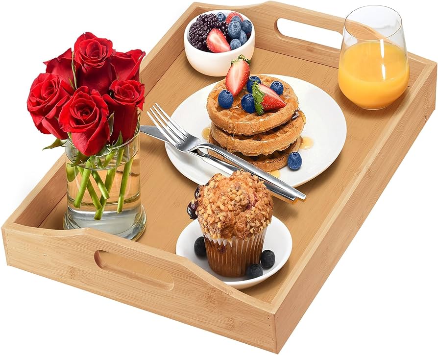 Bandeja de bambu servindo um café da manhã completo com panquecas, muffin e suco de laranja.