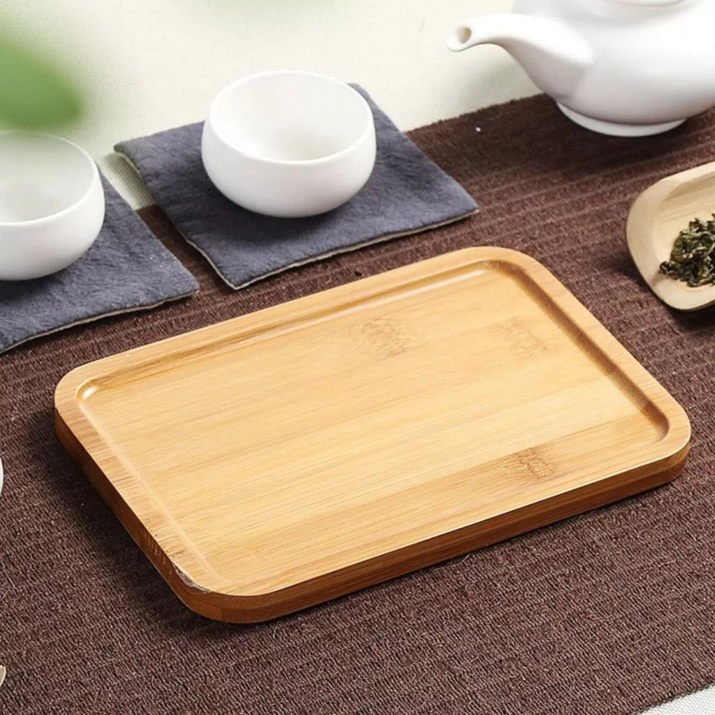 Bandeja retangular de bambu sobre mesa posta com utensílios de chá