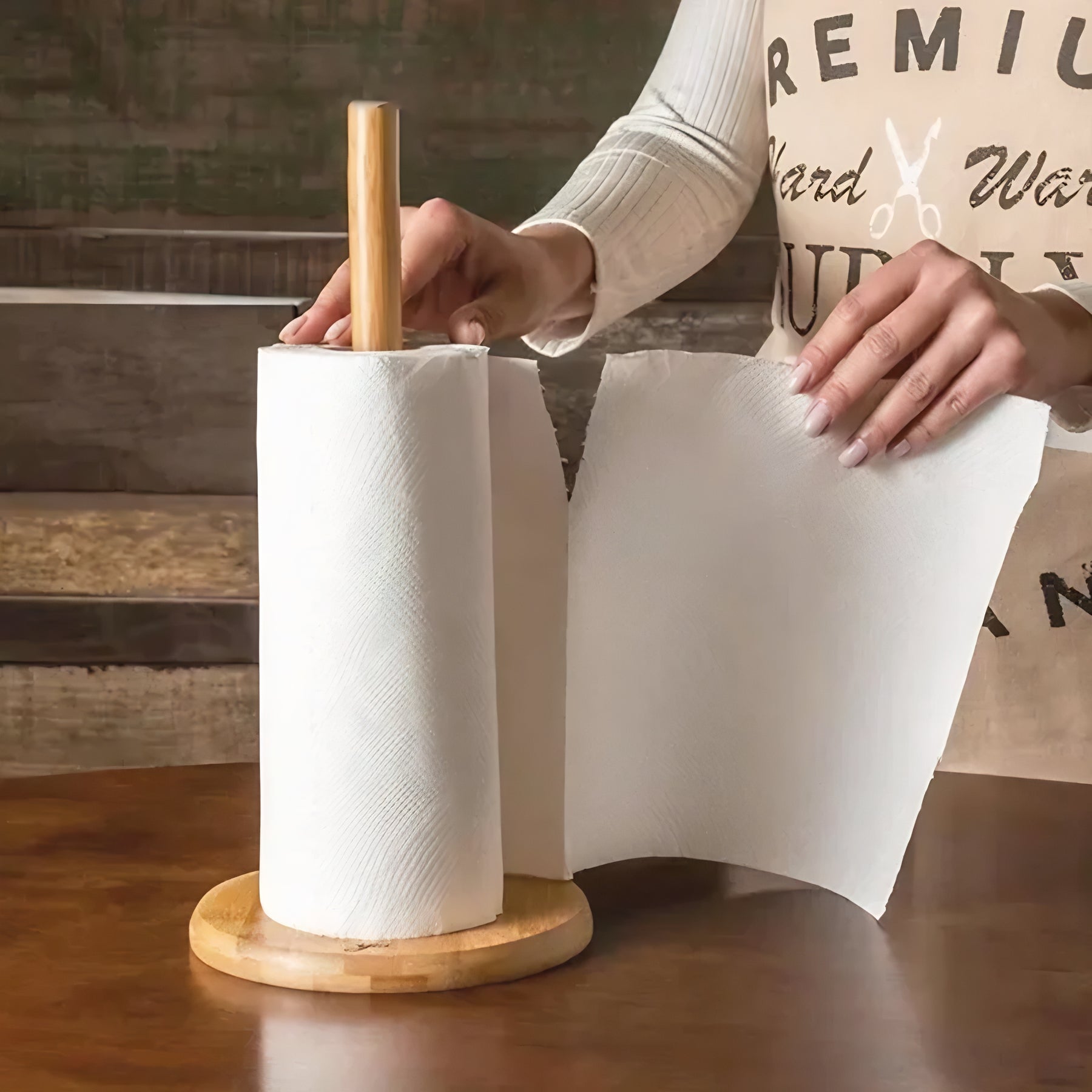 Suporte para papel toalha de bambu com base redonda, pessoa destacando folha de papel