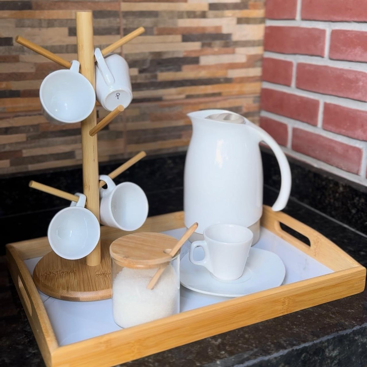 Bandeja retangular de bambu com xícaras, suporte de canecas, garrafa térmica branca e potinho de açúcar