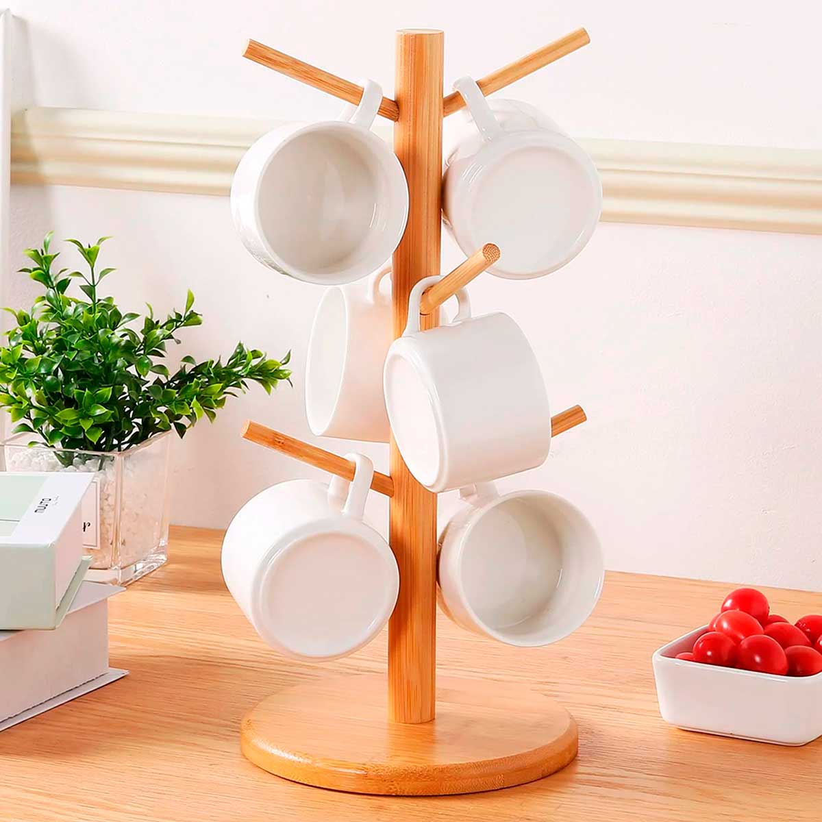 Suporte de bambu para xícaras com seis ganchos, organizando canecas de cerâmica branca em uma bancada.