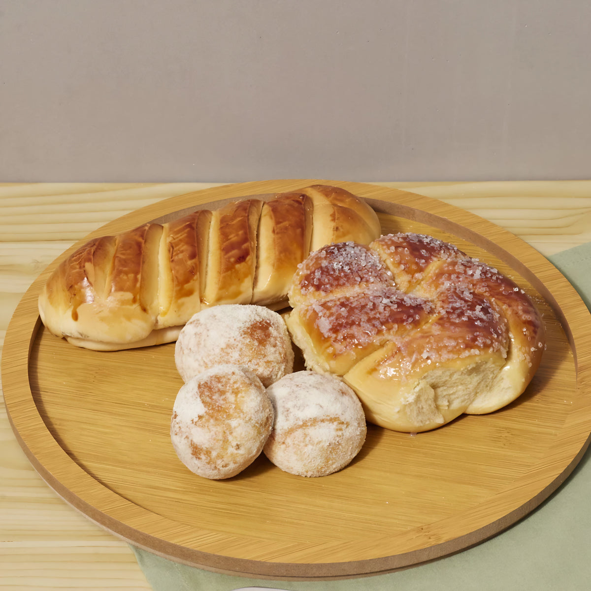 Prato redondo de bambu servindo uma refeição com um filé de frango grelhado e pães.