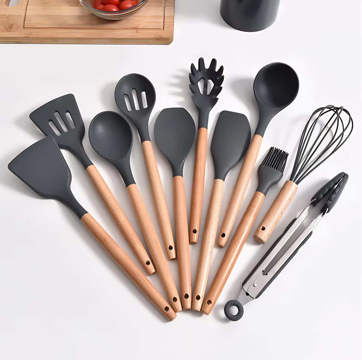 Conjunto de utensílios de cozinha com cabo de bambu e pontas de silicone na cor cinza escuro, dispostos em leque.