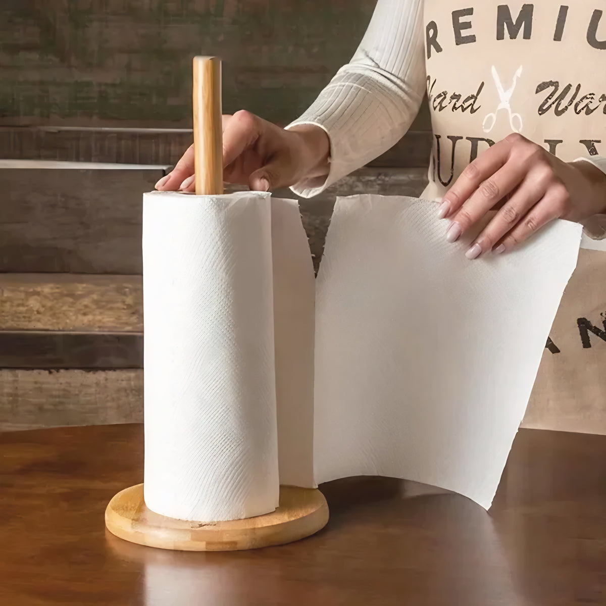 Suporte para papel toalha de bambu com base redonda, pessoa destacando folha de papel