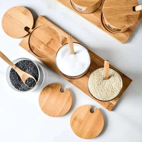 Potes de cerâmica com tampa de bambu, mostrando alho e cebola em pó para uso como porta-temperos.